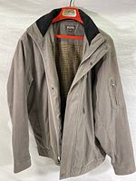 Front and open inside view of taupe Michael Kors jacket showing flannel and quilted lining with black collar.