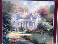 Close-up of the art print showing a house with a garden and trees, highlighting the artwork detail and color.