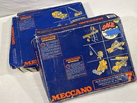 Overview of two blue vintage Meccano Enthusiast construction kits boxes showing front with images of yellow steel construction models such as crane and digger vehicles.