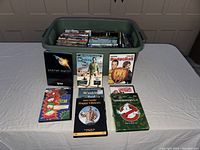 Set of six DVDs placed outside the bin to show example titles: Planet Earth, Breaking Bad, DodgeBall, Happy Gilmore, Ghostbusters 1 & 2, and an animated title.
