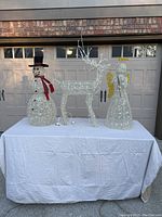 Full set of three Christmas yard decorations on white covered table: snowman, reindeer, angel