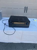 Front view of Denon AVR-3312CI AV receiver showing power button, display screen, front controls including a master volume knob and input selector.