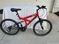 Side view of red Dynacraft Gauntlet mountain bike showing frame, tires, seat and chain.
