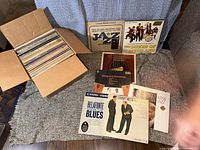 Box filled with approximately 65 vinyl records, and several individual album covers displayed including Jazz, Blues, and Dixieland genres.