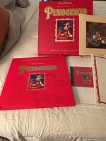 Overall view showing Pinocchio Deluxe LaserDisc edition in red box with lithograph and booklet.