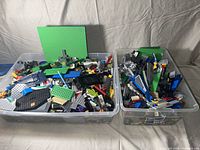 Top view showing two bins filled with assorted Lego pieces and two green base plates
