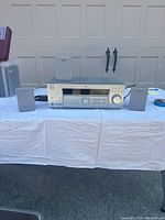 Sony STR-K502 receiver and two matching speakers placed on a white tablecloth outdoors against a garage door.