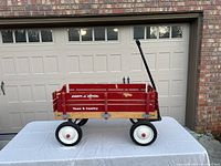 Side view of red wooden wagon with Radio Flyer and Town & Country logos, black handle, and white wheels