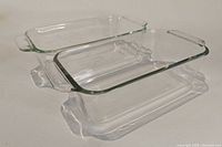 Two clear glass rectangular bread pans stacked one inside the other showing their shape and handles.