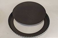 Photo showing the flat base plate pan placed on top of the fluted tart pan base, emphasizing the two-part pan set.