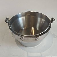 Front and slightly top view of the large stainless steel jam pan showing the interior and depth along with side handles.