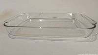 Side angle view of clear rectangular glass baking dish showing smooth edges and handle