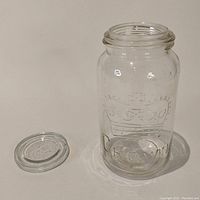 Front view of the clear glass Crown Mason jar with the lid off to the side, showing embossed crown and 'CROWN' lettering.