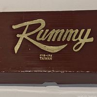 Top view of the wooden Rummy game box with gold lettering showing 'Rummy' and 'Taiwan 210-178'.
