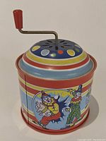 Front angle showing clown holding pig and colorful top with crank.