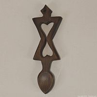 Front view of dark stained wooden Welsh love spoon with heart cutout design and a small spoon bowl.