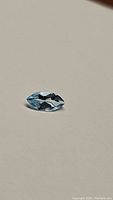 Topaz gemstone marquis cut shown from front angle on neutral background.