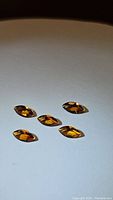 Five marquise cut Madeira citrine gemstones arranged on flat surface showing clarity and color.