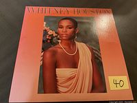 Front cover of the 1985 Whitney Houston vinyl album showing the iconic orange cover with Whitney Houston's portrait.