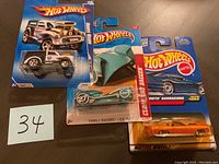 Three Hot Wheels toy cars in package, includes gray Morris Wagon, teal Thrill Racers Ice 72, and purple South Barracuda 1969.