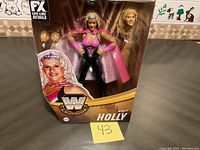 WWF Molly Holly doll solo shot in packaging showing full figure, cape, extra head, and branding.