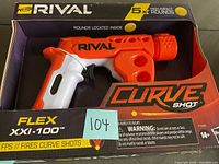 Orange and white Nerf Rival Curve Shot Flex XXI-100 blaster in packaging showing front view with visible branding and included rounds.