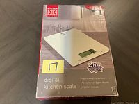Photo of Kitchen Living digital kitchen scale in unopened packaging showing front of box with product image and features