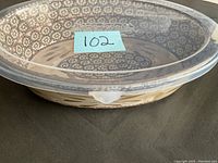 Side view of the ceramic pie dish with plastic lid attached, showing the rim and pattern