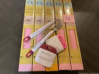 Four packages of pink permanent vinyl paper with crafting tools on top
