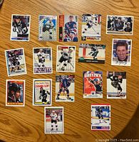 Top side of 17 Wayne Gretzky hockey cards arranged on a wooden surface showing front images with player in multiple hockey poses and uniforms.