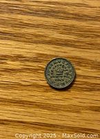 Photo of one side of the 1847 3Fs Half Dram Token Coin showing crown and date