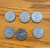 Six 1945 Canada 5 cent nickels arranged on wooden surface showing obverse (torch and denomination)