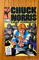 Front cover photo of Chuck Norris Karate Kommandos issue #1 comic showing title, main character in karate pose, and armed figures in background.