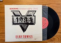 Front of the vinyl record cover showing the Eurythmics 'Sexcrime (Nineteen Eighty-Four)' album artwork with visible water damage on the bottom right corner.