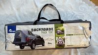 Photo of the original carrying bag of the Napier Backroadz Truck Tent showing product label with model name and picture of tent set up on truck bed.