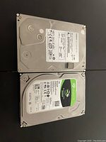 Photo showing both hard drives: one 1TB Seagate BarraCuda and one 650GB drive, both with labels visible