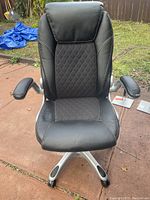 Front view of the black office gaming computer chair showing diamond-stitched seat and backrest, padded armrests, and metal base with caster wheels.