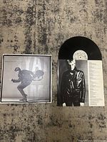 Full view of the vinyl record alongside the album cover and inner sleeve with artist image and lyrics.