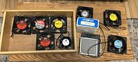 Overview of all 9 fans including boxed units and loose fans laid out on a table showing various brands and sizes.