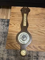 Full view of the wood case vintage weather instrument showing the thermometer, barometer, and hygrometer aligned vertically.