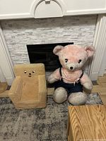 Photo showing vintage squishy kids chair next to giant teddy bear in front of a fireplace.