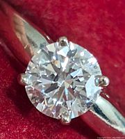 Close-up view of round brilliant-cut diamond set in white gold band