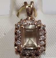 Rectangular-cut diaspore pendant with diamond halo, front view