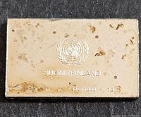 Photo showing one side of the silver bar with United Nations emblem, SUOMI/FINLAND text and silver purity mark 925/1000 plus date '76'. Surface has tarnishing spots.