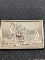 Close-up of silver bar front showing detailed depiction of Hatshepsut's Punt Ship with sails and crew.