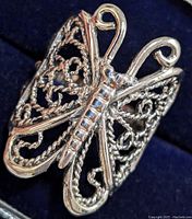 Close-up angled photo showing the detailed design of the butterfly wings and body on the silver ring.