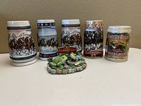 Front view showing five steins plus frogs figurine