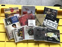 All 13 CD cases spread out on yellow surface