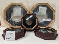 Five octagonal collector plate frames displayed; two large sealed, three small unwrapped