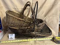 Three stacked wicker baskets showing overall forms and size reference tape